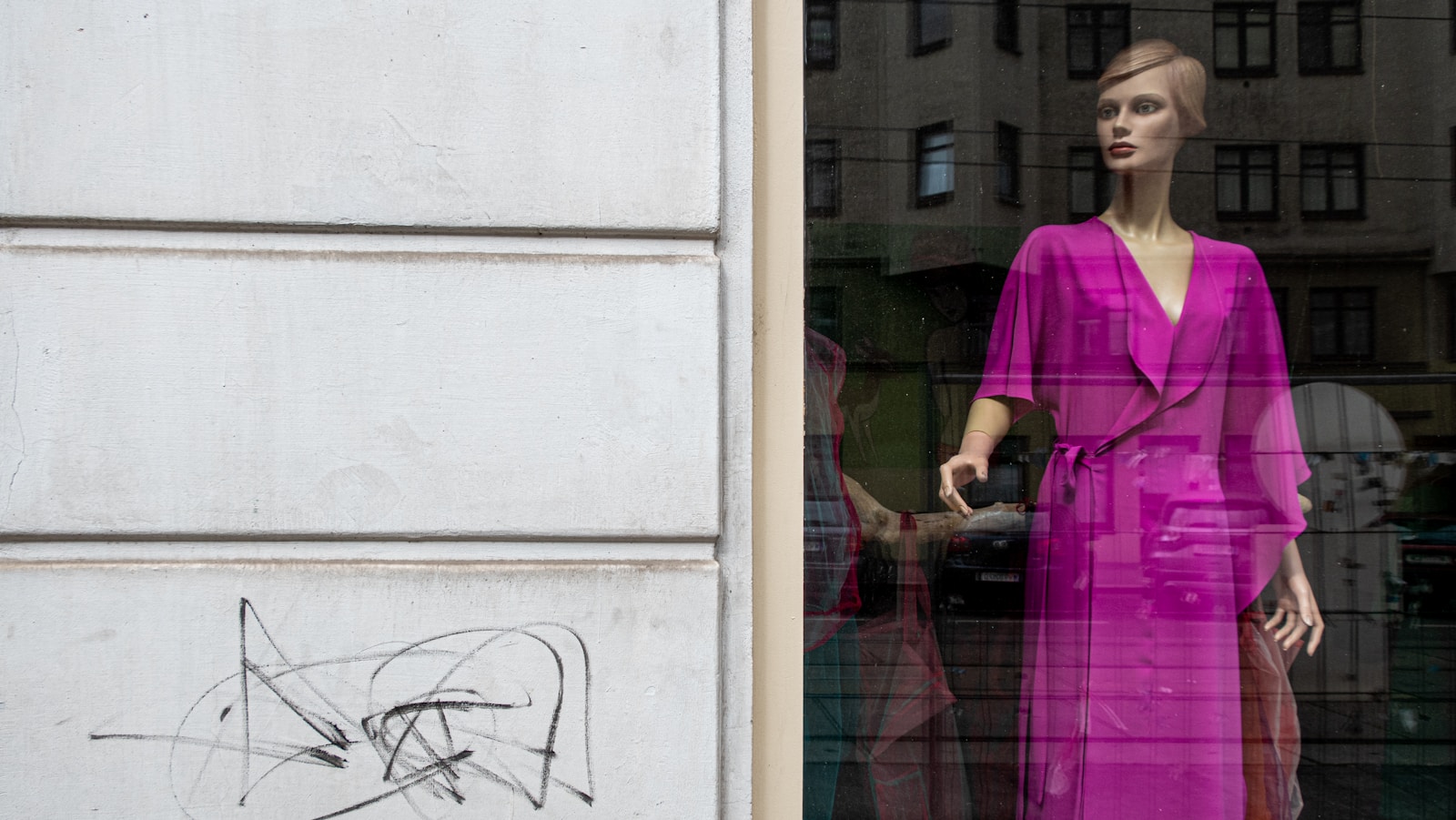 a mannequin wearing a pink dress and a pink jacket